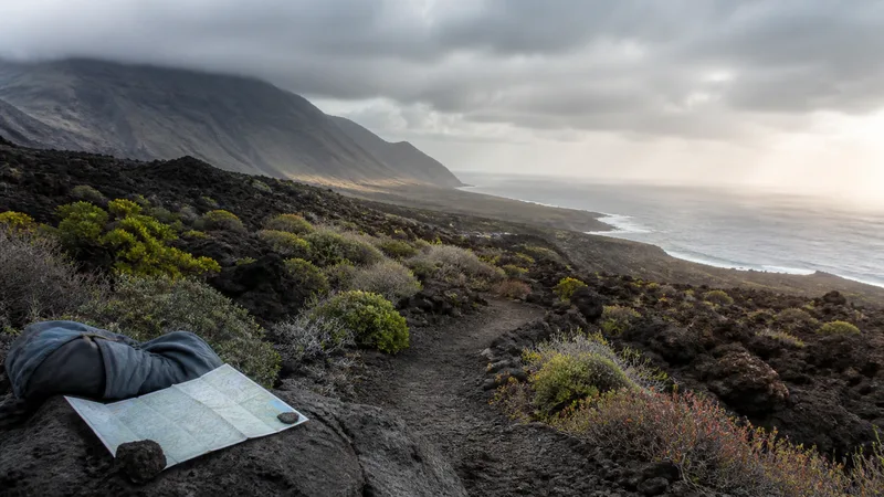 Sendero volcánico canario entre nube de ladera y luz sobre el océano