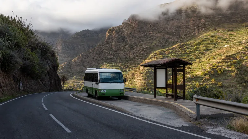 Guagua en una parada de montaña entre bancales y nubes