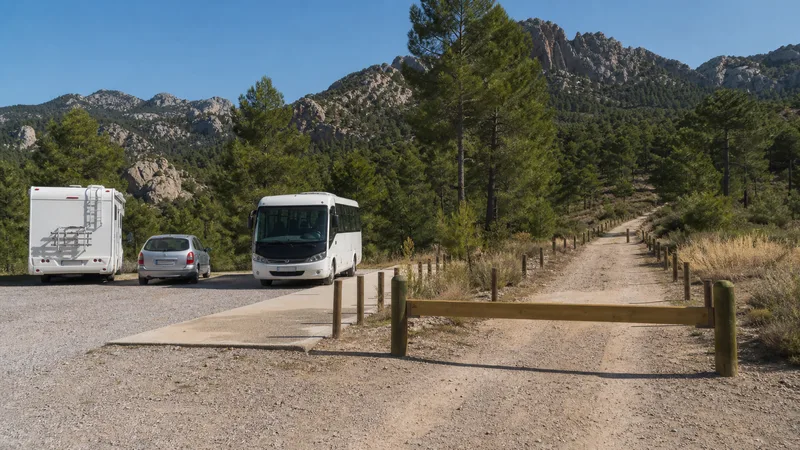 Vehículos estacionados junto a una lanzadera y una pista natural cerrada al tráfico