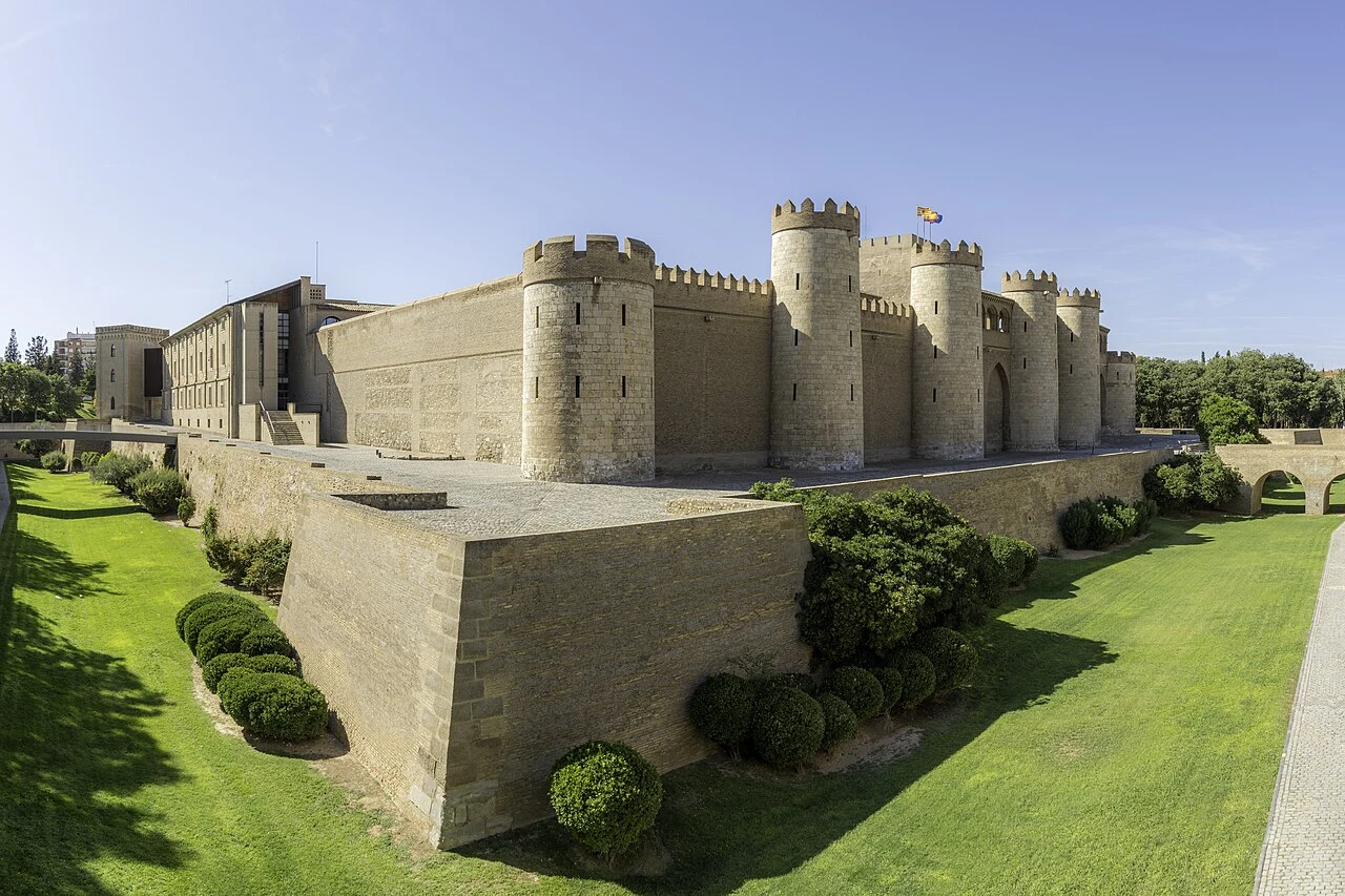 Palacio de la Aljafería con torreones y foso ajardinado