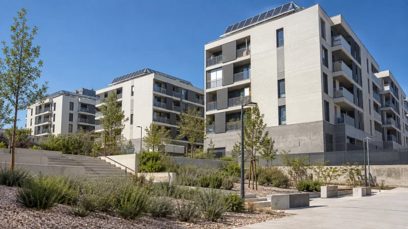 Conjunto residencial moderno con paneles solares y zonas verdes en una mañana despejada
